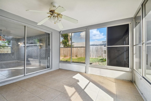 unfurnished sunroom with ceiling fan