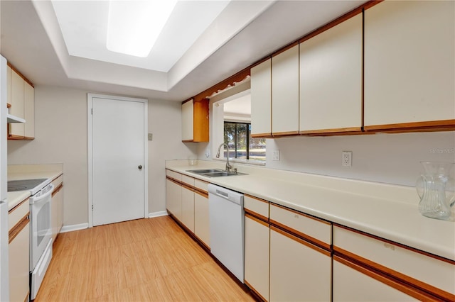 kitchen with white cabinetry, white appliances, sink, and light wood-type flooring