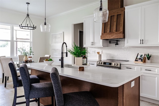 kitchen with white cabinets, a kitchen island with sink, light wood-type flooring, and electric stove