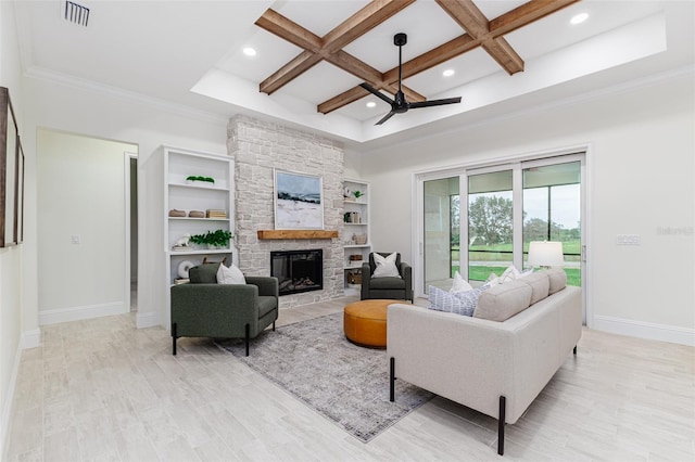 living room featuring coffered ceiling, a stone fireplace, beamed ceiling, light hardwood / wood-style floors, and ceiling fan