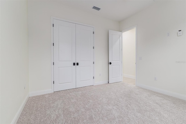 unfurnished bedroom featuring a closet and light carpet