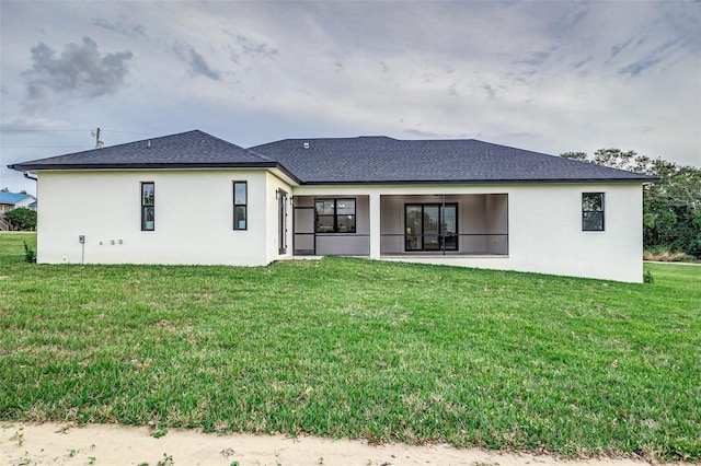 rear view of property featuring a lawn