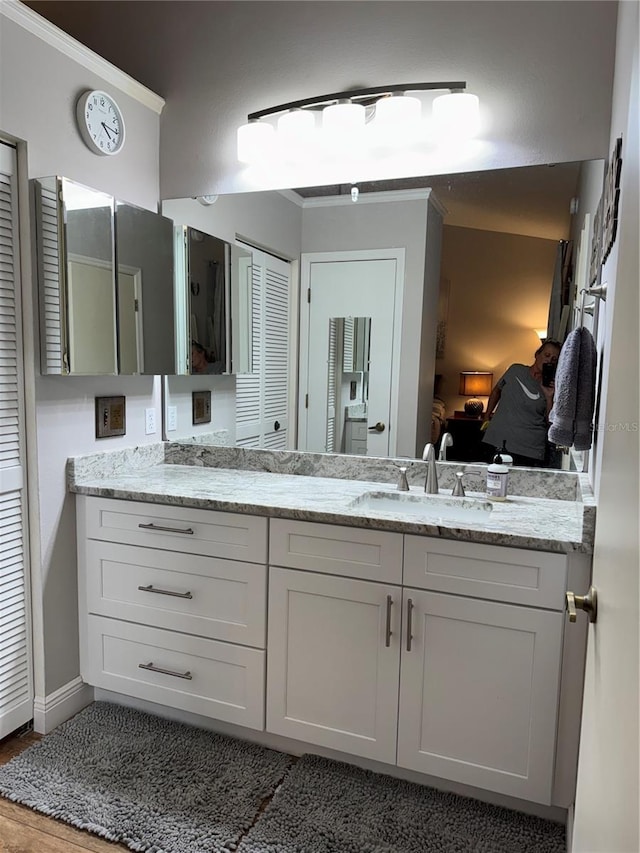 full bath featuring a closet, connected bathroom, vanity, and baseboards