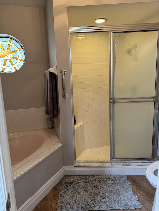 full bathroom with wood finished floors, a shower stall, and a bath