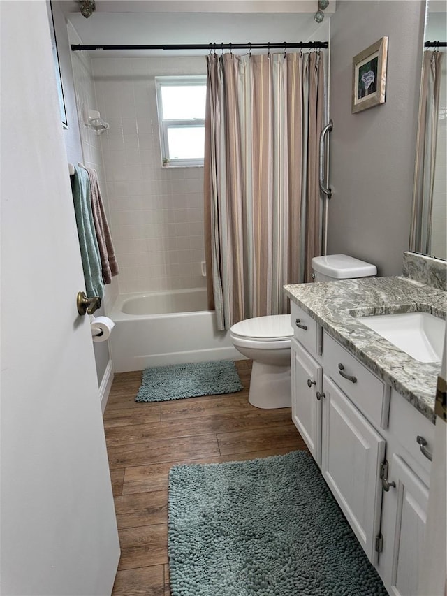 bathroom with shower / bath combination with curtain, vanity, toilet, and wood finished floors