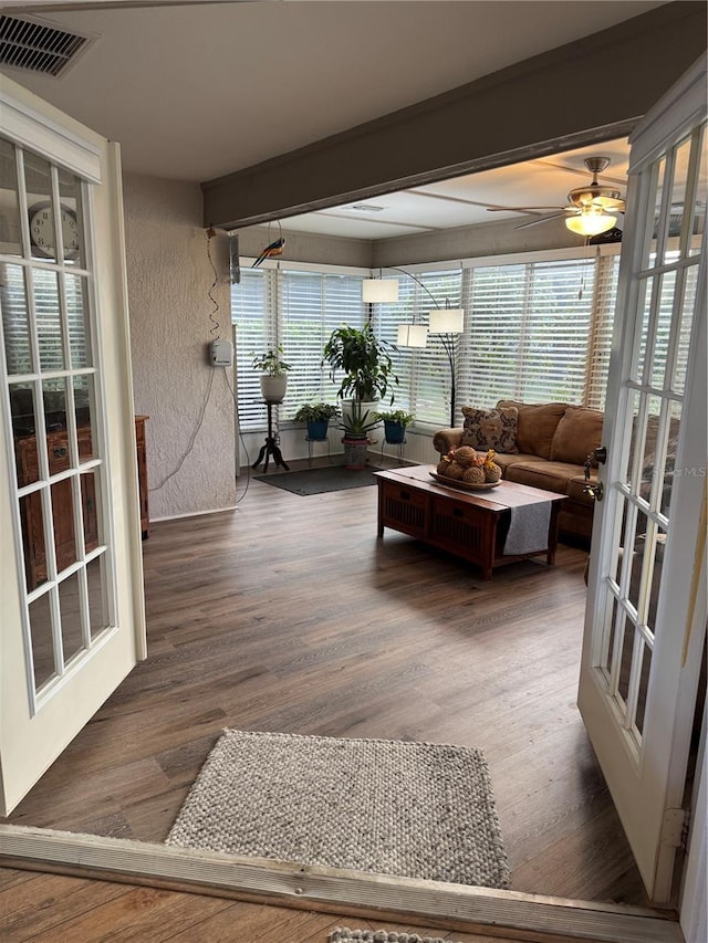 sunroom / solarium with beam ceiling, visible vents, and a ceiling fan