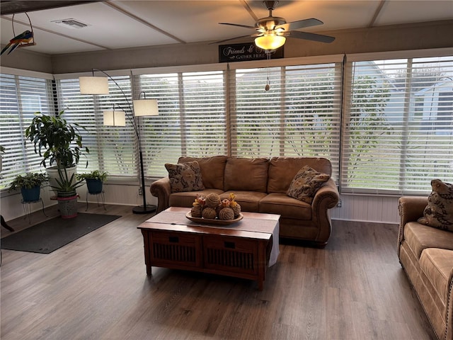 living area with visible vents, ceiling fan, and wood finished floors