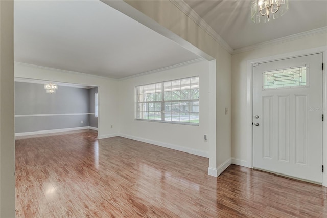 foyer entrance with a notable chandelier, hardwood / wood-style floors, and crown molding