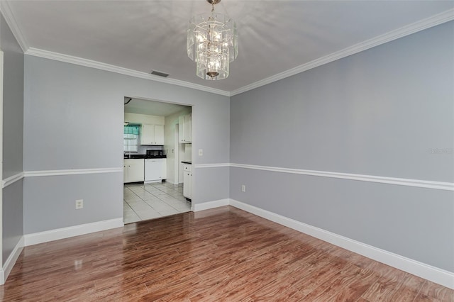 unfurnished room with crown molding, light hardwood / wood-style flooring, and an inviting chandelier