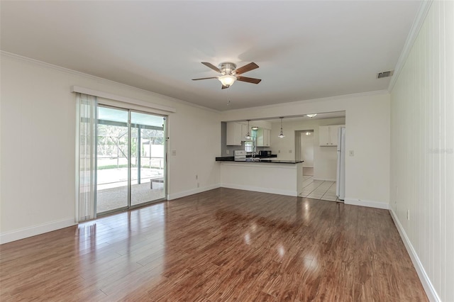 unfurnished living room featuring light hardwood / wood-style floors, ornamental molding, and ceiling fan