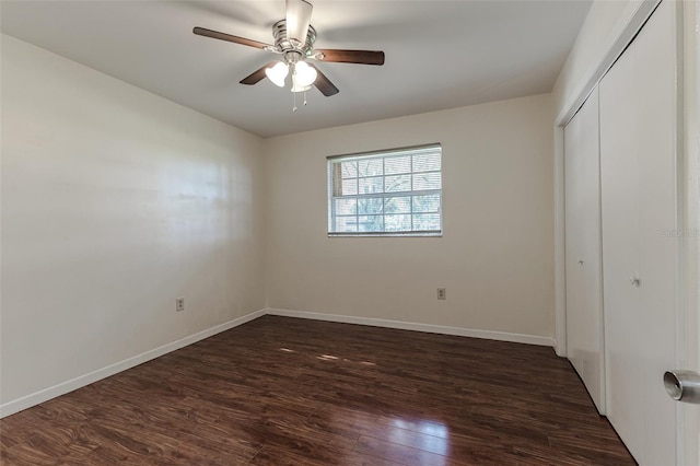 unfurnished bedroom with dark hardwood / wood-style flooring, a closet, and ceiling fan