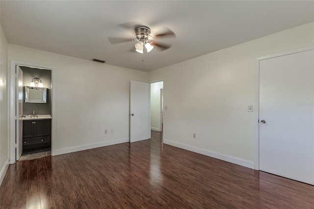 unfurnished bedroom featuring sink, ceiling fan, ensuite bathroom, and dark hardwood / wood-style flooring