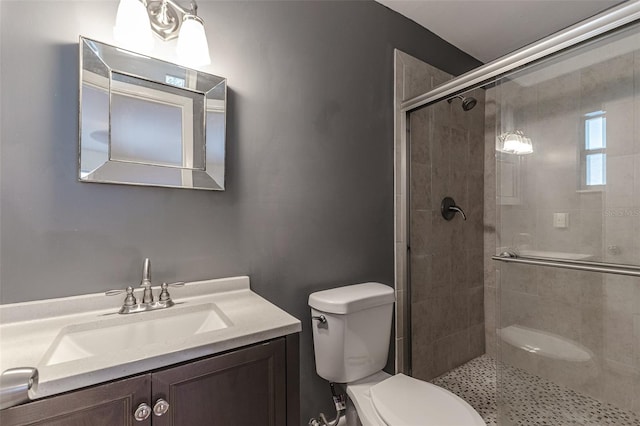 bathroom featuring vanity, toilet, and a shower with shower door