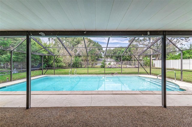 view of swimming pool featuring glass enclosure, a patio area, and a lawn