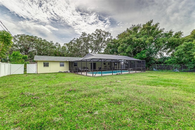 view of yard with a fenced in pool and glass enclosure