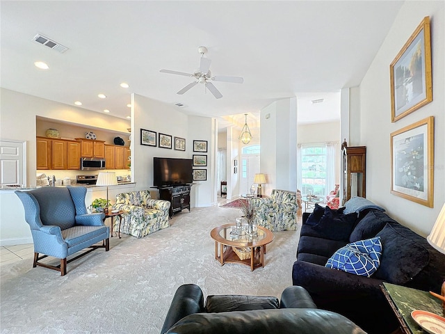 carpeted living room with ceiling fan