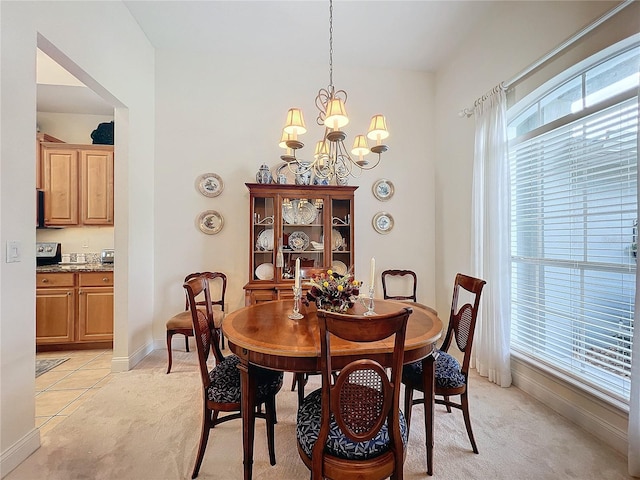 dining room featuring a notable chandelier and light colored carpet