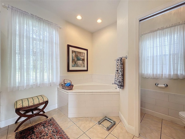 bathroom with tile patterned floors and tiled bath