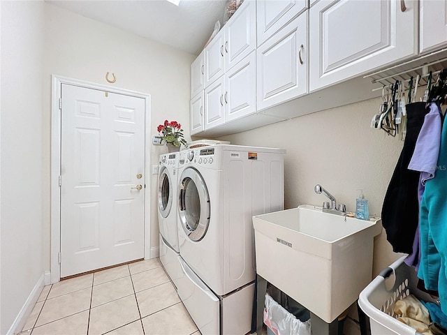 clothes washing area featuring cabinets, light tile patterned flooring, sink, and washer and clothes dryer