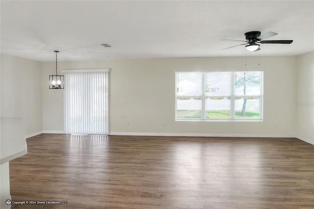 spare room featuring ceiling fan with notable chandelier and dark hardwood / wood-style floors