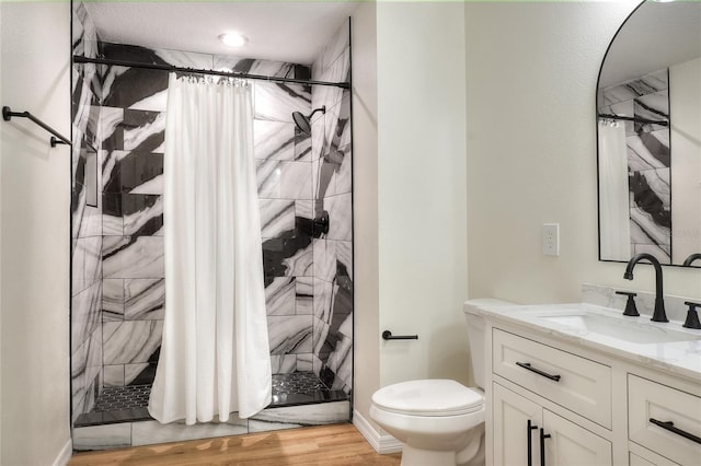 bathroom featuring hardwood / wood-style floors, vanity, toilet, and walk in shower