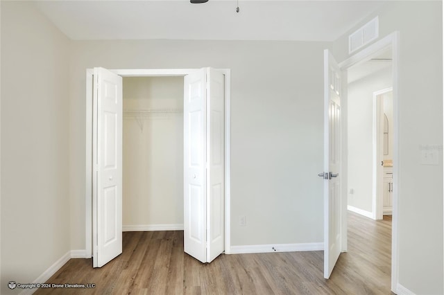 unfurnished bedroom featuring light wood-type flooring and a closet