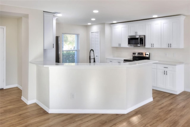 kitchen with sink, light hardwood / wood-style flooring, white cabinets, and appliances with stainless steel finishes