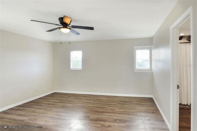 unfurnished room with hardwood / wood-style flooring, ceiling fan, and a wealth of natural light