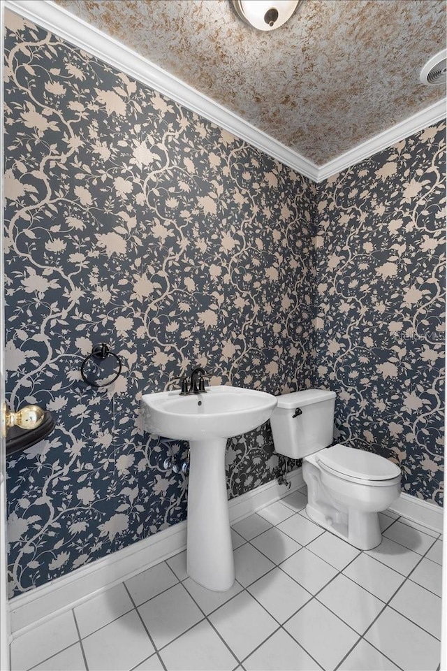 bathroom featuring toilet, tile patterned flooring, and ornamental molding