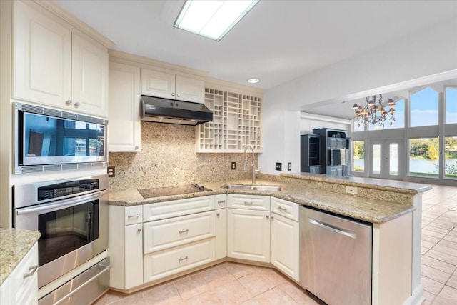 kitchen featuring an inviting chandelier, sink, decorative backsplash, kitchen peninsula, and stainless steel appliances