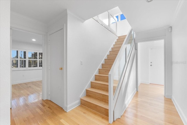 staircase featuring crown molding and hardwood / wood-style flooring