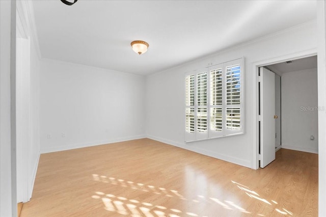 unfurnished room with crown molding and light hardwood / wood-style flooring