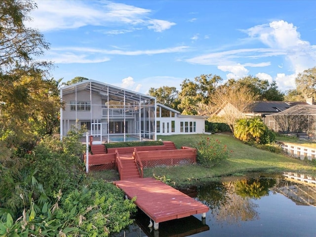 rear view of property with a yard, a pool, a water view, and glass enclosure