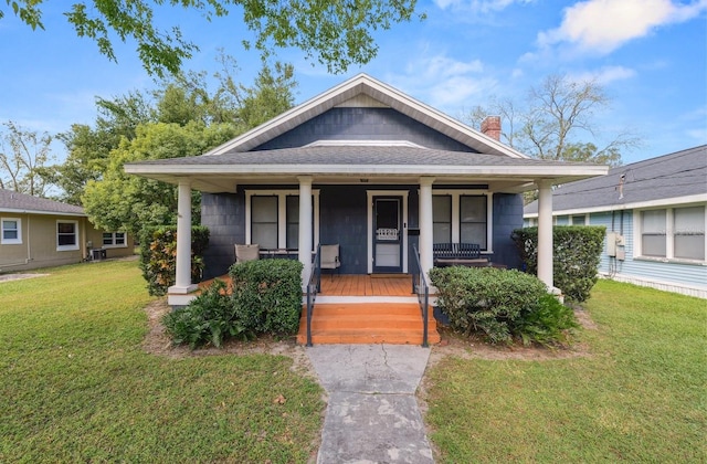 bungalow featuring covered porch, cooling unit, and a front lawn