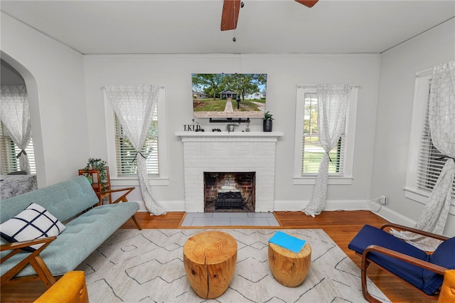 living room featuring hardwood / wood-style flooring, a fireplace, and ceiling fan