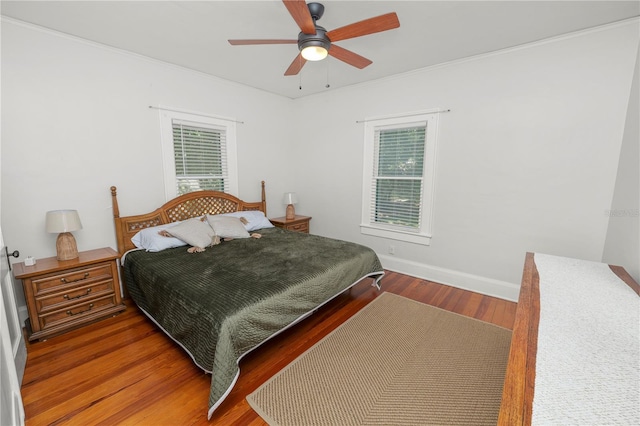 bedroom with ceiling fan, crown molding, and wood-type flooring