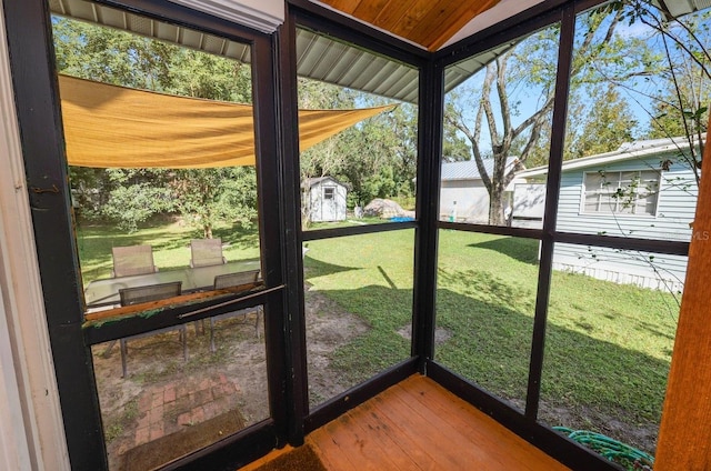 unfurnished sunroom with lofted ceiling, a healthy amount of sunlight, and wooden ceiling