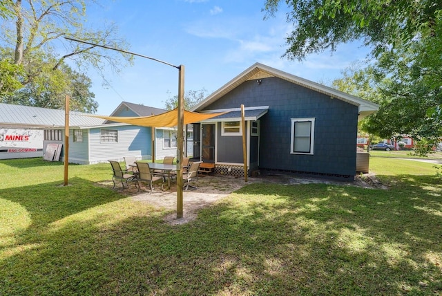 back of property with a yard and a patio area