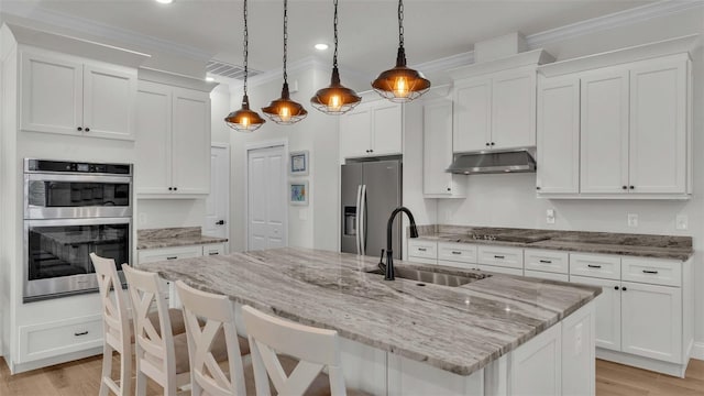 kitchen featuring white cabinetry, a center island with sink, pendant lighting, and appliances with stainless steel finishes