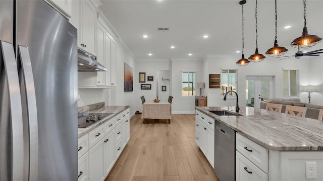 kitchen featuring stainless steel appliances, white cabinets, sink, a kitchen island with sink, and decorative light fixtures