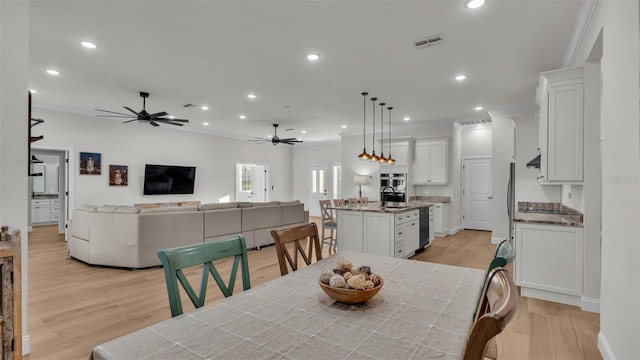 dining room featuring ornamental molding, light hardwood / wood-style floors, and ceiling fan