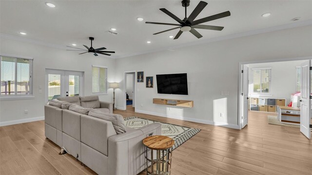 living room with french doors, light wood-type flooring, ornamental molding, and ceiling fan