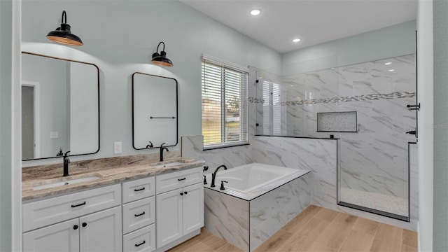 bathroom featuring independent shower and bath, vanity, and hardwood / wood-style floors