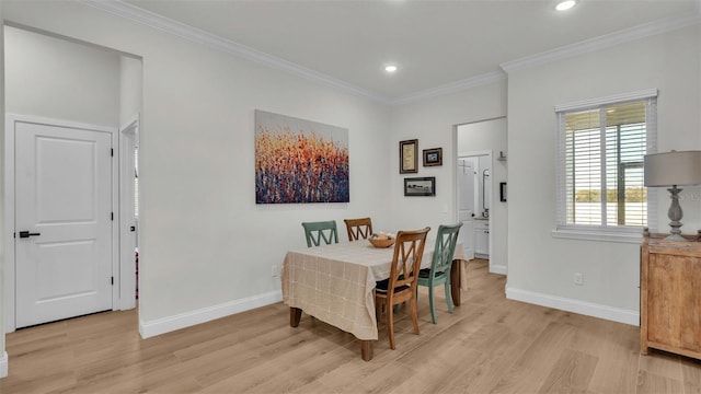 dining space featuring light wood-style floors, baseboards, and ornamental molding