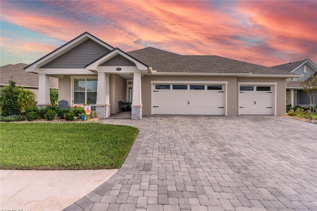 7929 Lake James Blvd, Lakeland, FL 33810 - view of front of property featuring decorative driveway, an attached garage, stucco siding, a front yard, and stone siding