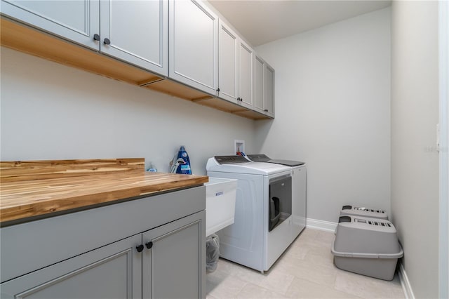 7929 Lake James Blvd, Lakeland, FL 33810 - laundry area featuring cabinet space, washer and clothes dryer, and light tile patterned flooring