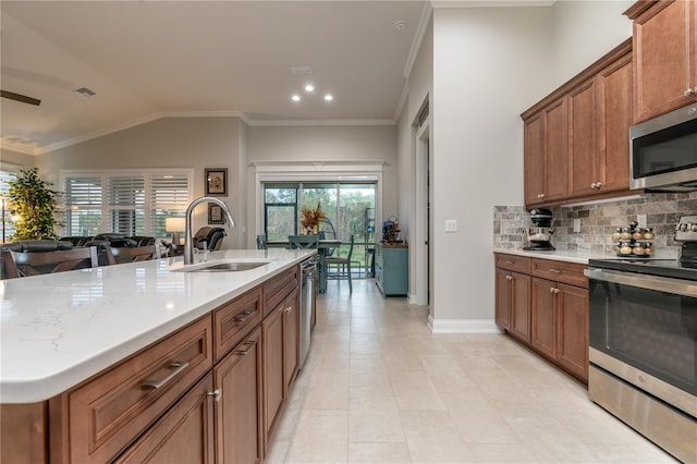 kitchen with sink, backsplash, stainless steel appliances, vaulted ceiling, and a center island with sink