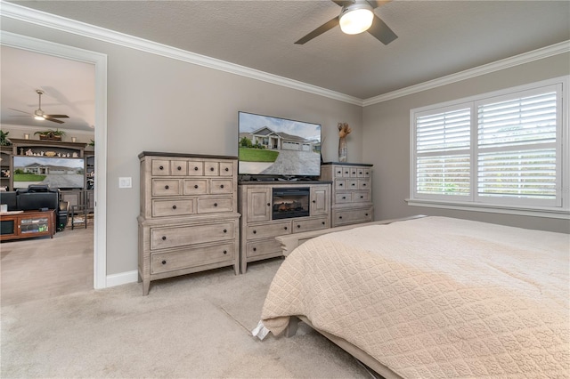 bedroom featuring ornamental molding, light carpet, a textured ceiling, and ceiling fan