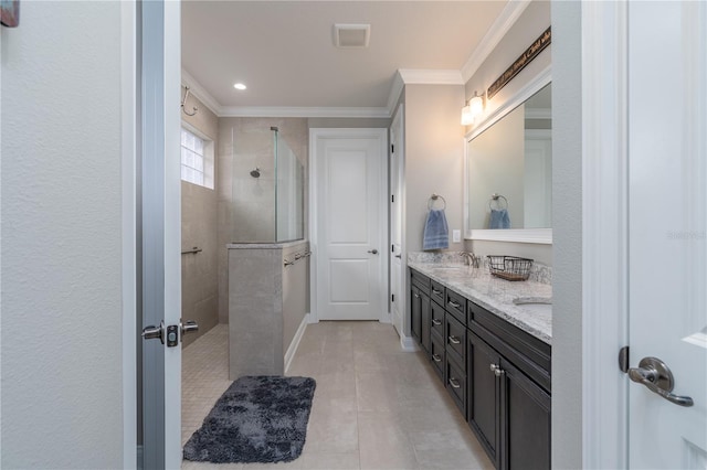 bathroom featuring vanity, tile patterned floors, ornamental molding, and tiled shower