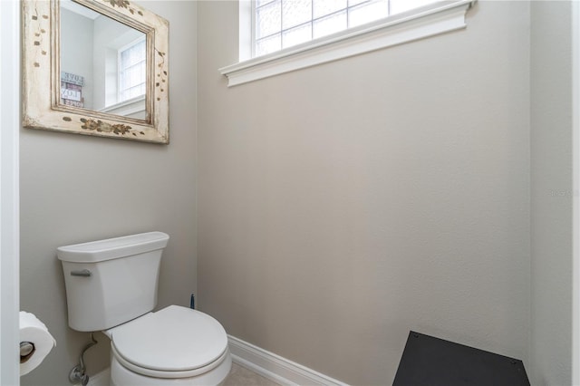 bathroom with toilet and a healthy amount of sunlight